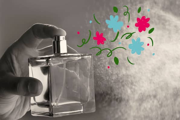 A perfume bottle spraying illustrated flowers.