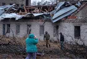 Residents walk at a site of a Russian missile strike in Dnipro, Ukraine, on Thursday.