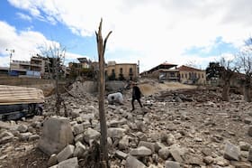 A man walks near the site of the historic Al-Manshiya building damaged in the aftermath of Israeli strikes, near the Roman ruins in Baalbek, Lebanon, on Thursday. (Thaier Al-Sudani/Reuters)