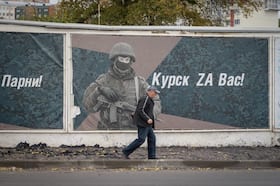 A man walks past a wall in Kursk adorned with banners honoring Russian servicemen on Oct. 17.