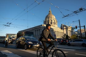 San Francisco residents pass City Hall on their commutes.